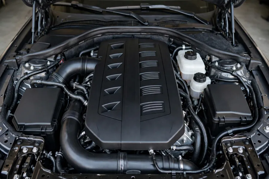 Clean generic BMW engine bay with plastic engine cover, photographed in soft studio light