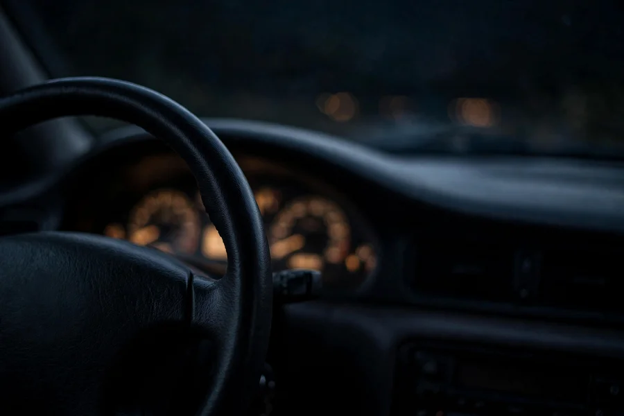 A dim BMW dashboard viewed from the driver's seat while attempting to start the car
