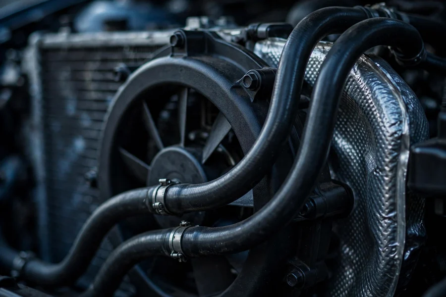 Radiator, electric cooling fan, and coolant hoses in a BMW engine bay