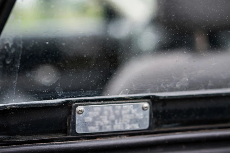 Close-up of a car's VIN plate viewed through the windshield glass