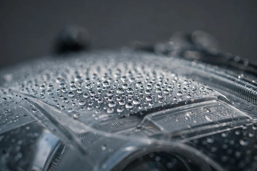 Close-up of fine moisture droplets on the inside of a BMW 3 Series headlight lens