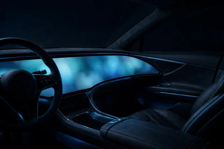 Dark car cockpit with a wide curved display glowing at night