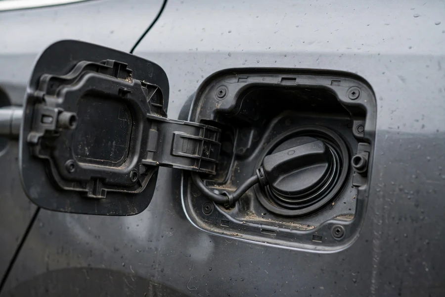Car fuel filler door flipped open showing the fuel cap area