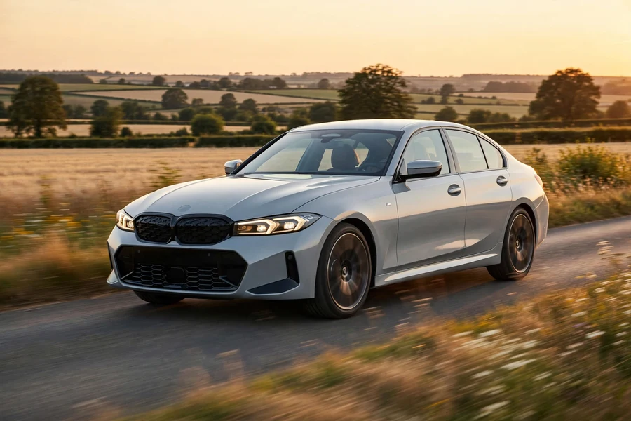 BMW 3 Series driving on an open rural road at sunset