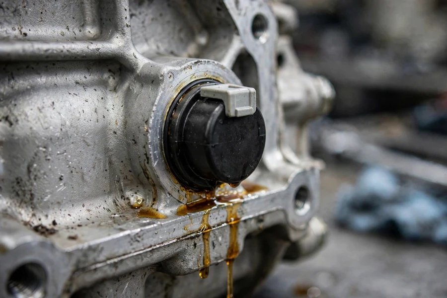 Close-up of the round electrical connector plug on a BMW ZF transmission with fluid seeping around the seal
